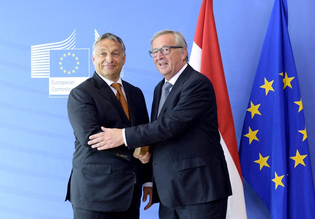 Hungary's Prime Minister Viktor Orban  (L) shakes hands with European Union Commission President Jean-Claude Juncker of Luxembourg prior to their meeting at the European Union Commission headquarter in Brussels on September 3, 2015. Orban warned on September 3 that the wave of mostly Muslim refugees coming to Europe threatens to undermine the continent's Christian roots -- an idea rejected by German Chancellor Angela Merkel -- and insisted the migrant crisis was a German problem, not a European one as he defended his government's handling of thousands of refugees flooding into his country.  AFP PHOTO / THIERRY CHARLIER (Photo by THIERRY CHARLIER / AFP)