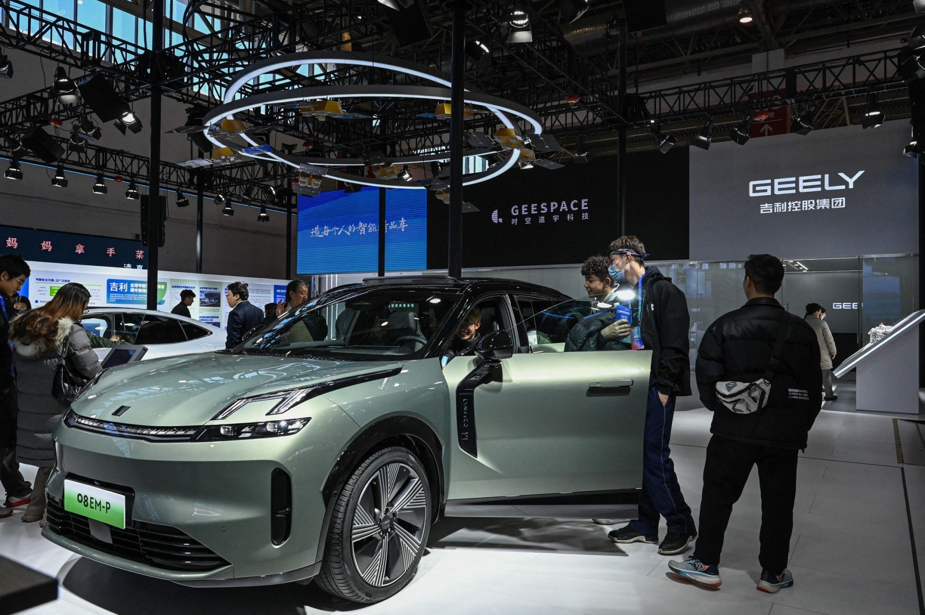 Ciemnozielony samochód elektryczny, a wokół tłum ludzi. To oficjalna prezentacja pojazdu chińskiej marki Geely