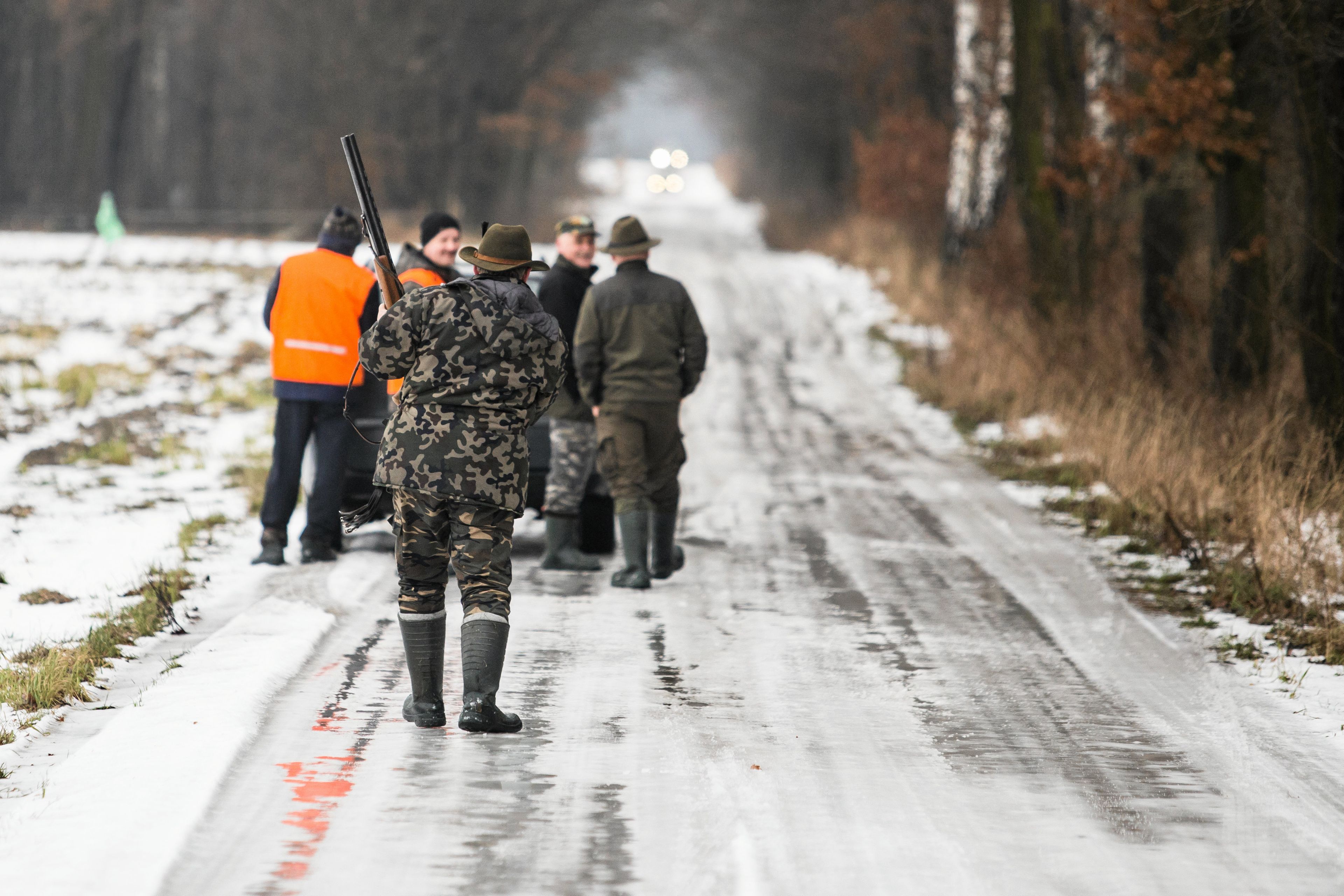 myśliwi idą ośnieżoną ścieżką