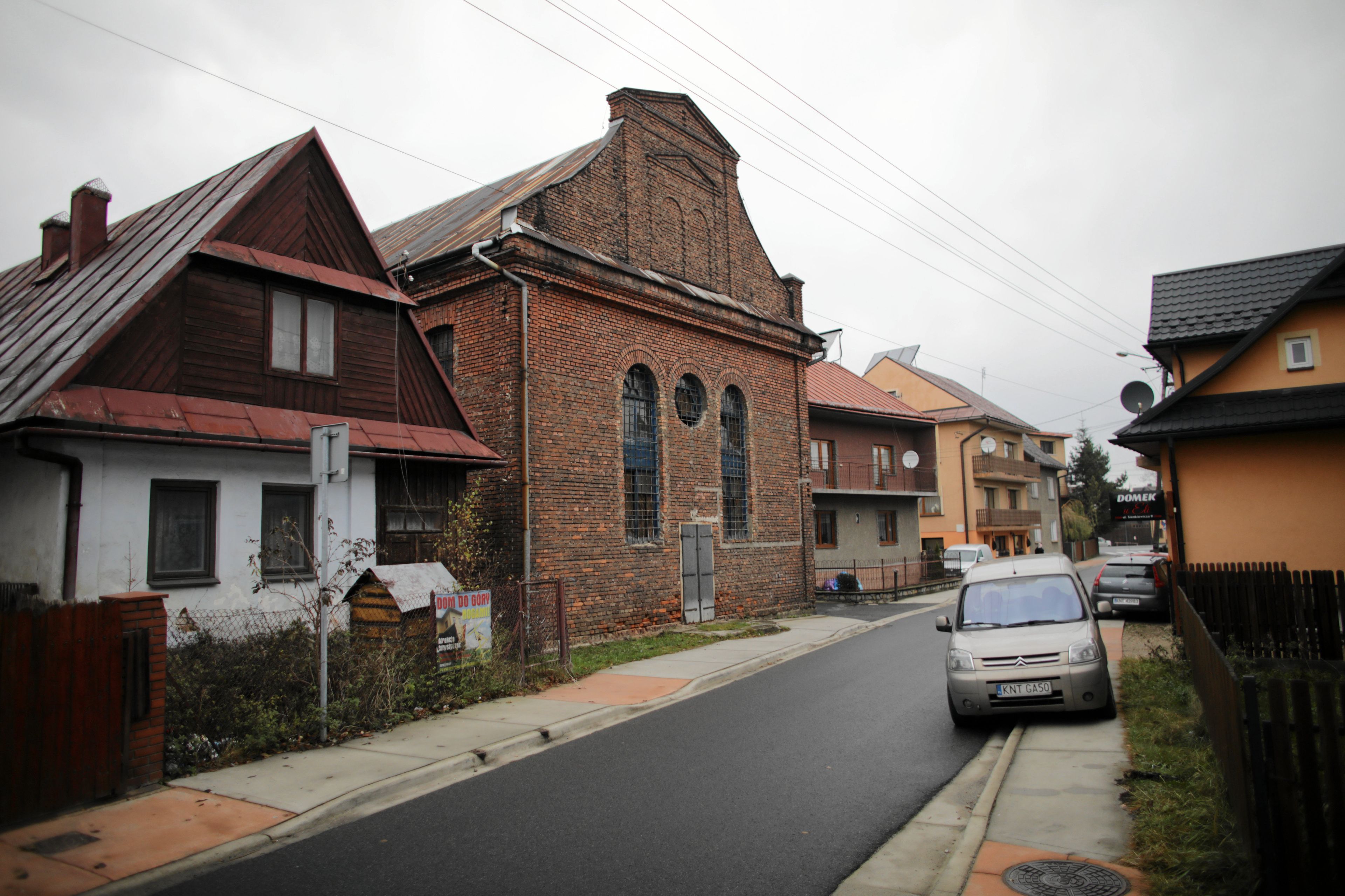 Ceglana synagoga pośród innych budynków przy ulicy