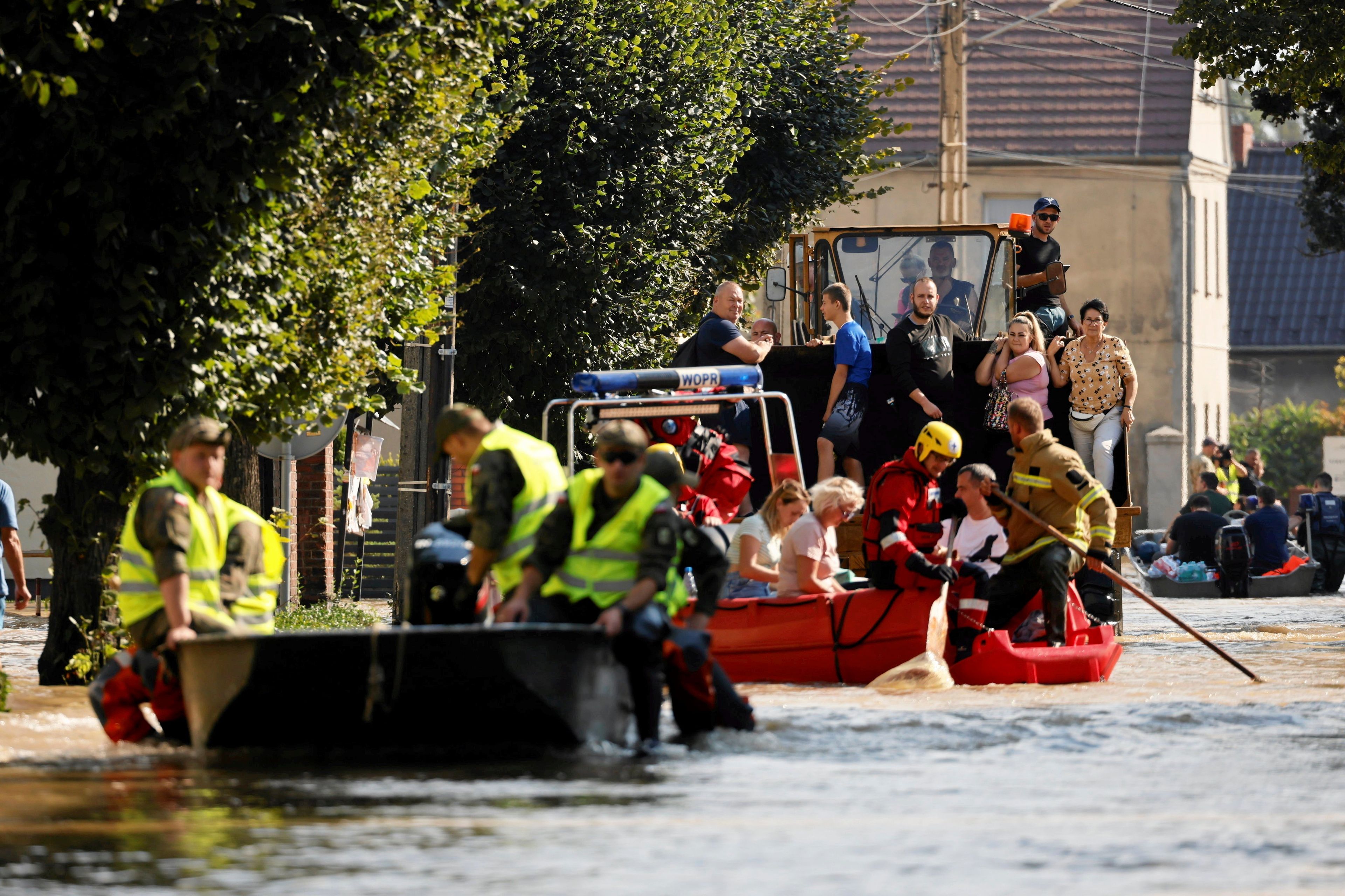 Na zdjęciu zalana ulica miasta Lewin Brzeski, ratownicy transportują łodziami mieszkańców