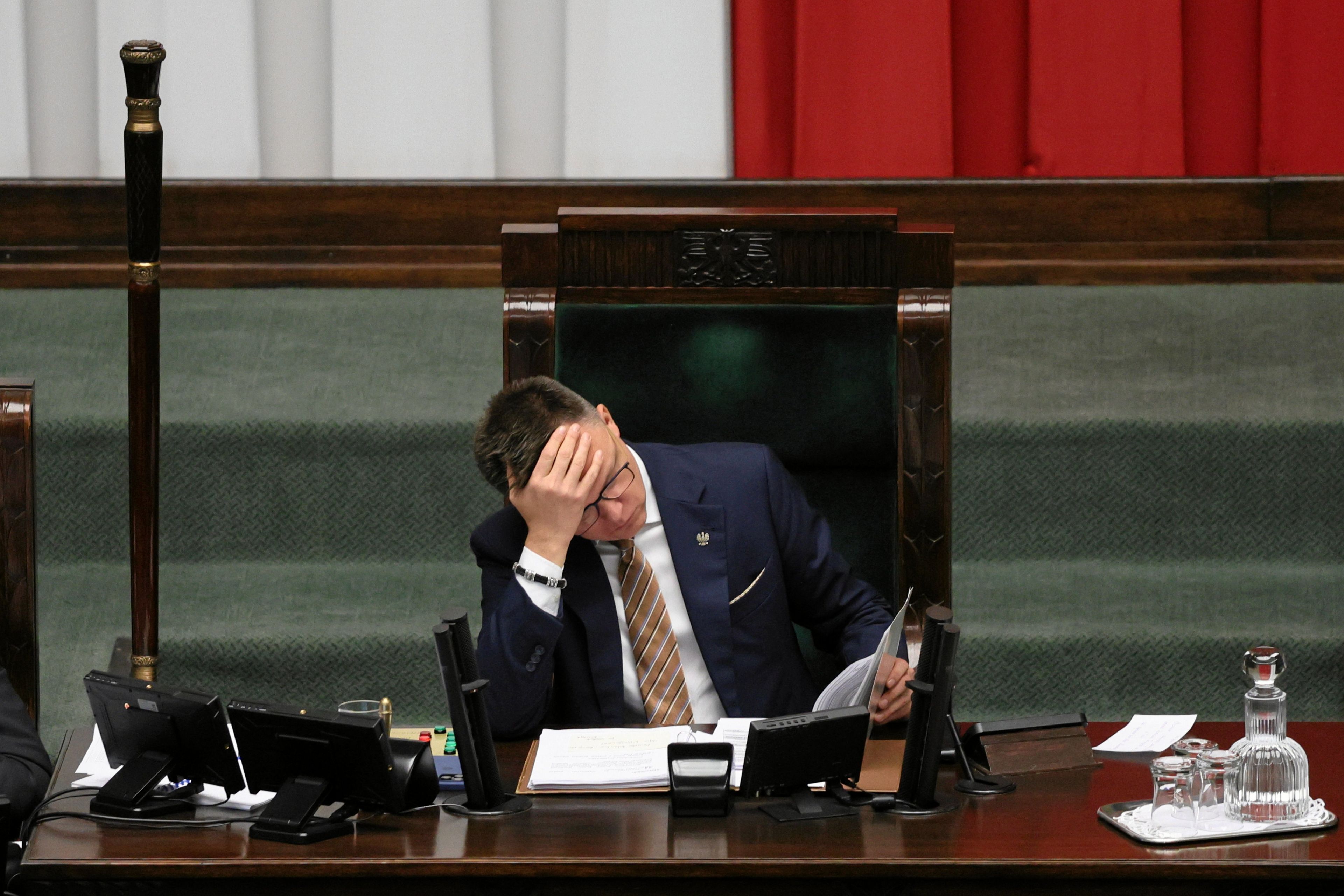 Szymon Hołownia w fotelu marszałka łapie się za głowę