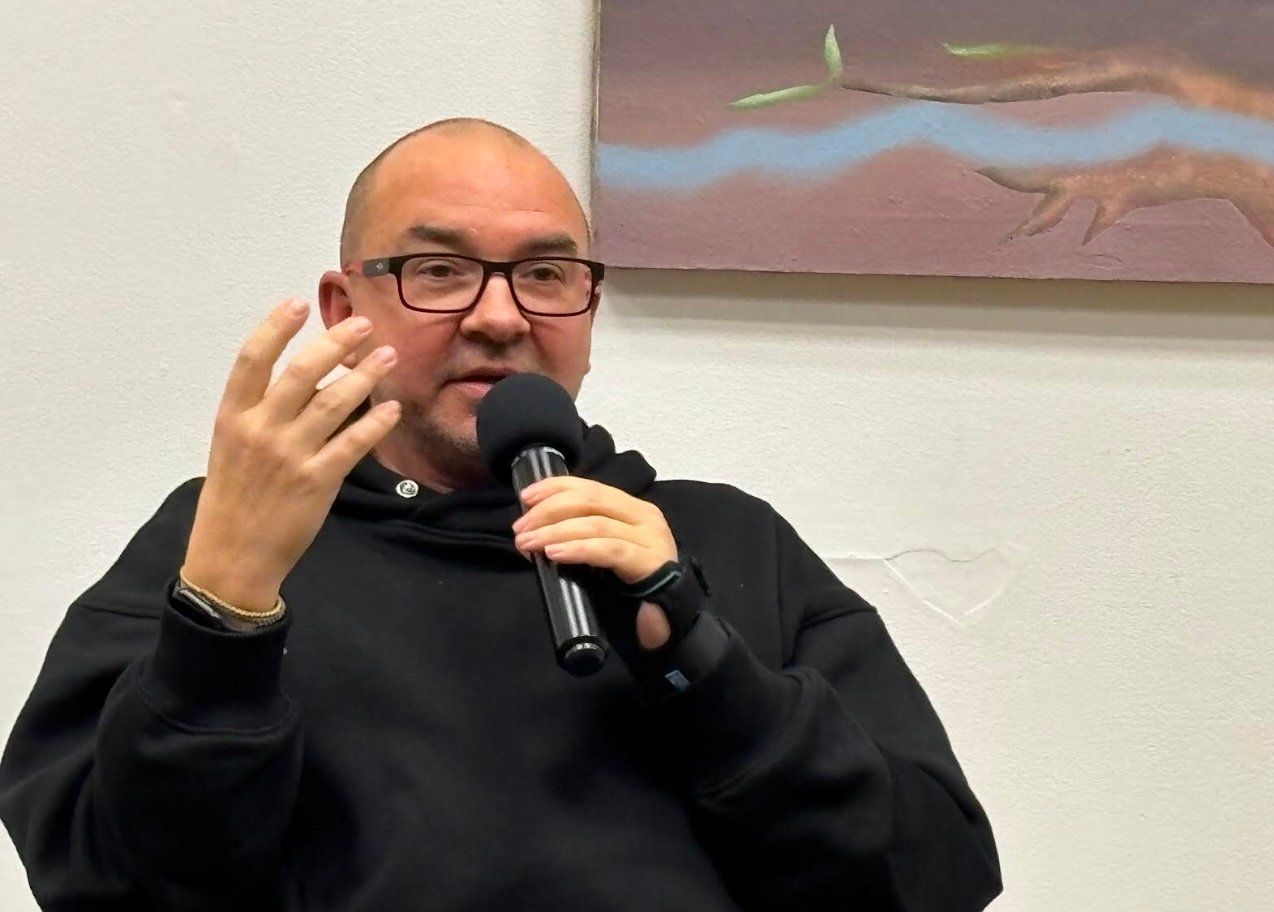 Mężczyzna w czarnej bluzie z mikrofonem