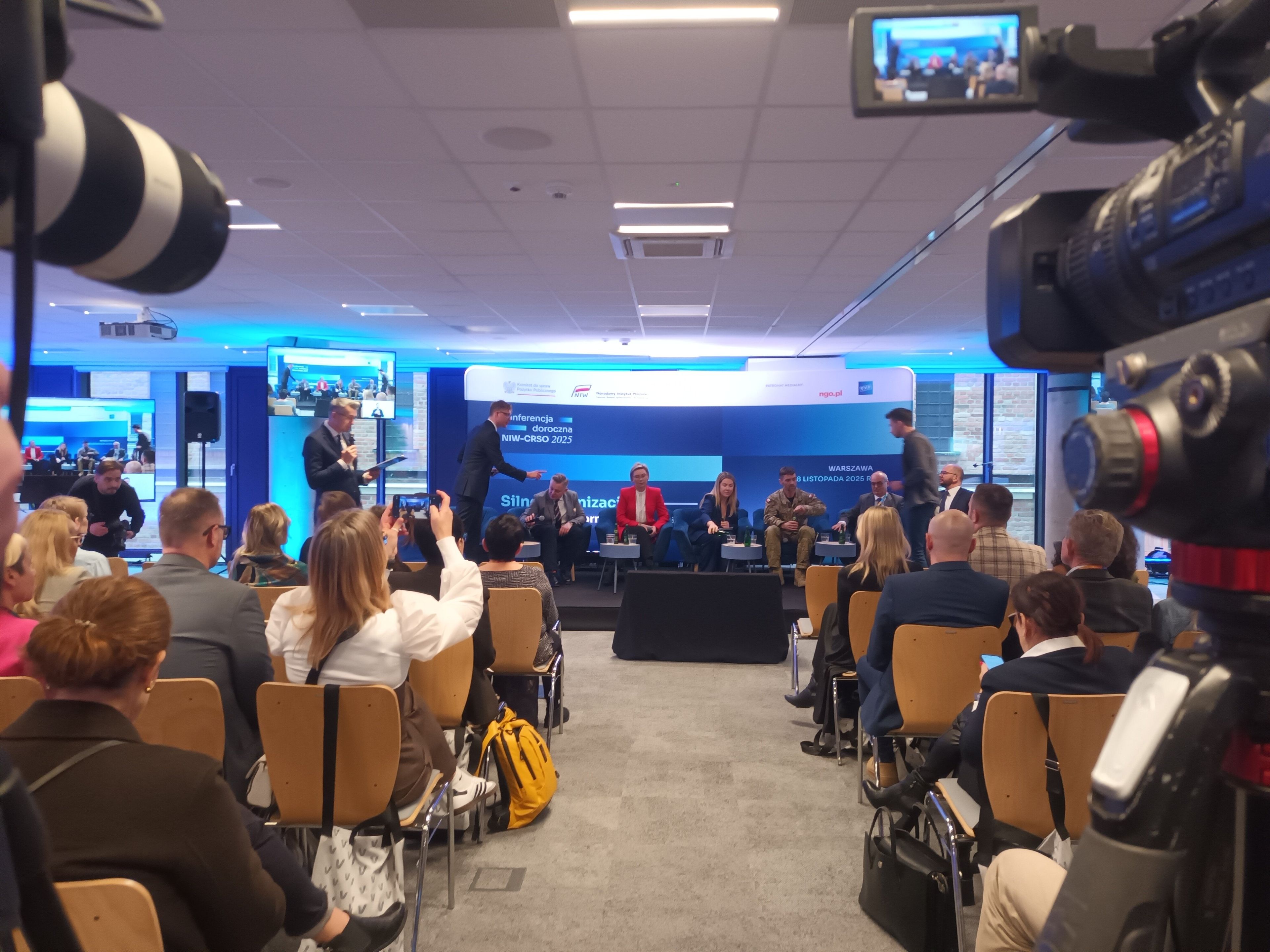 Ludzie na sali, w głebi paneliści