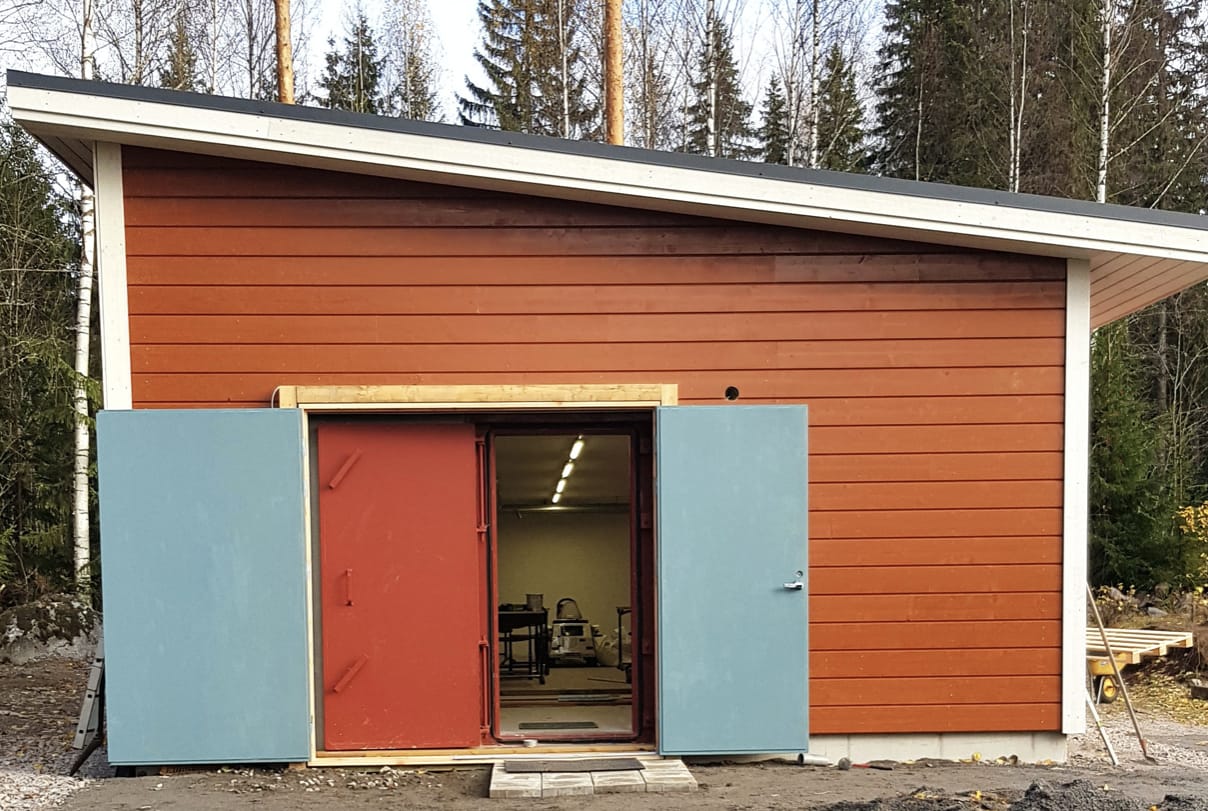 Mały budynek ze spadzistym dachem obity deskami pomalowanymi na brązowo