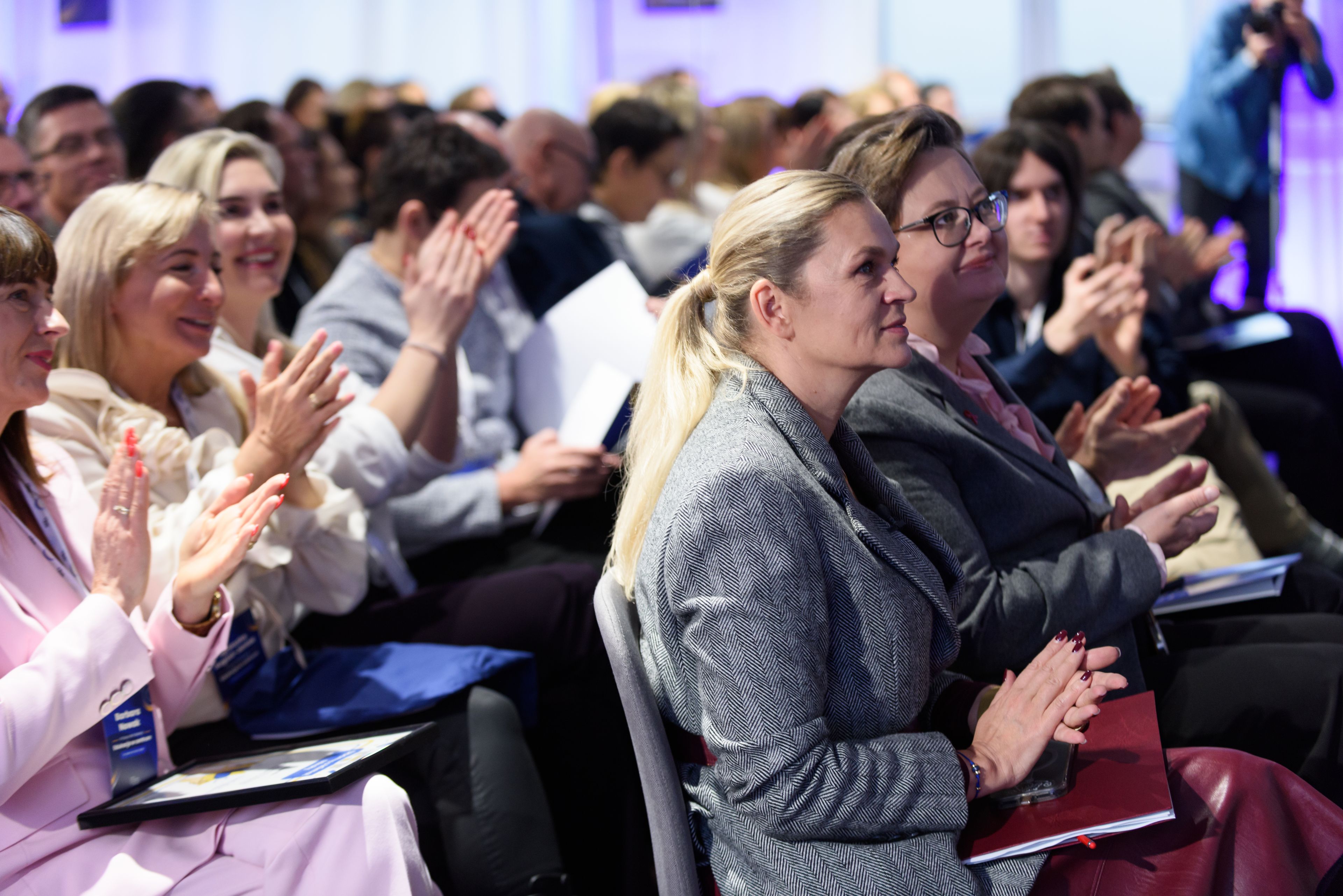 Pełna sala klaszczących osób