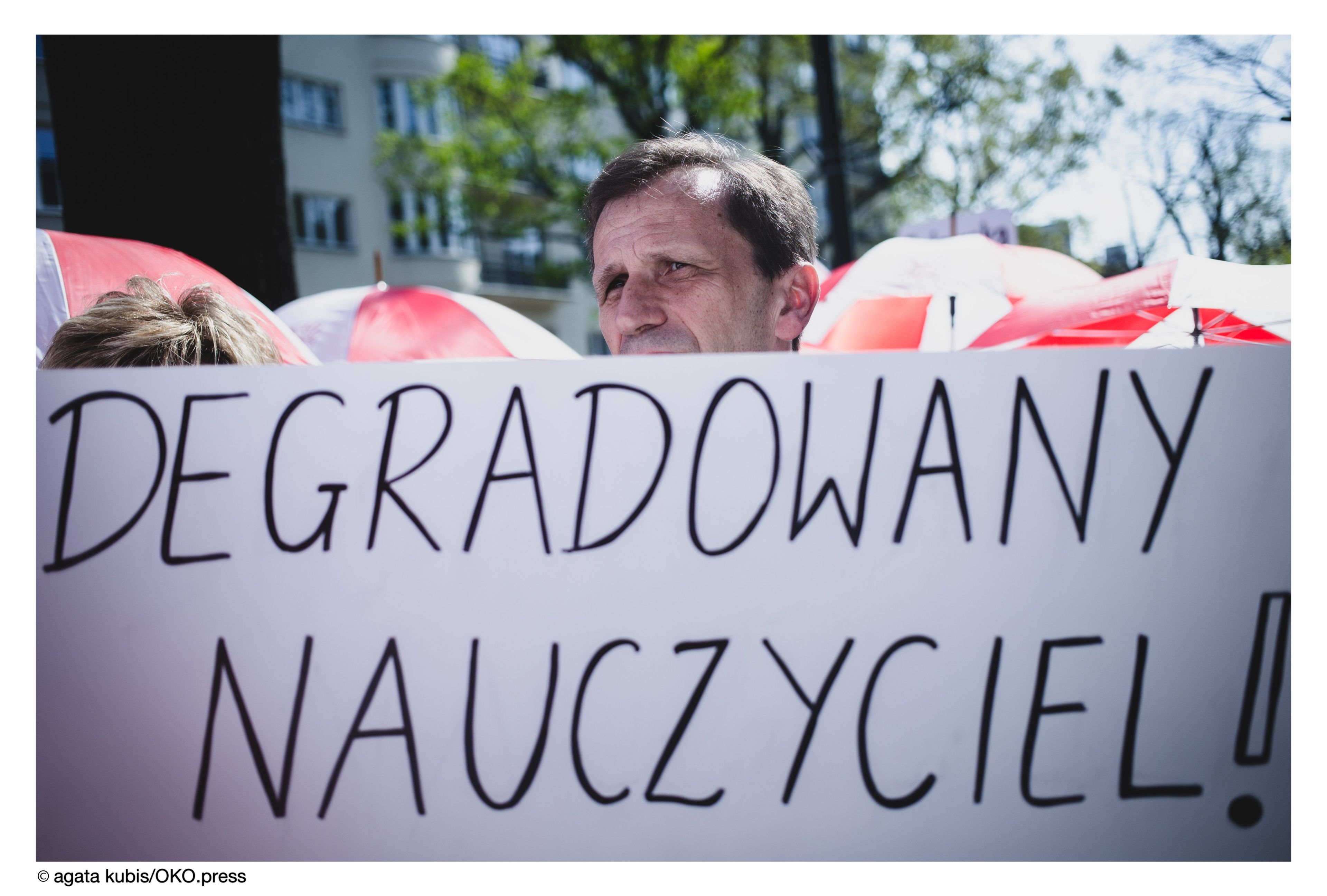 Nauczyciel z banerem: degradowany nauczyciel