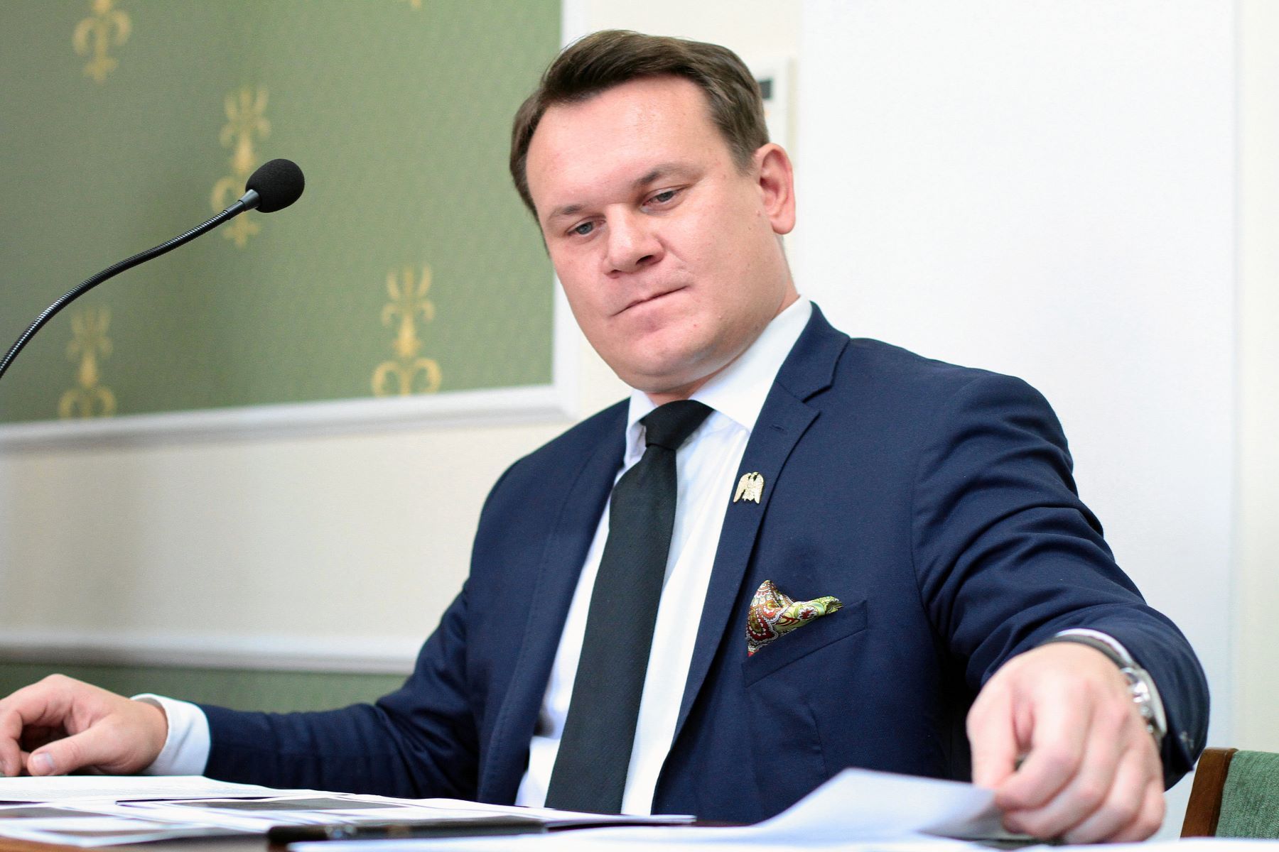 Męzczyzna w garniturze przegląda dokumenty