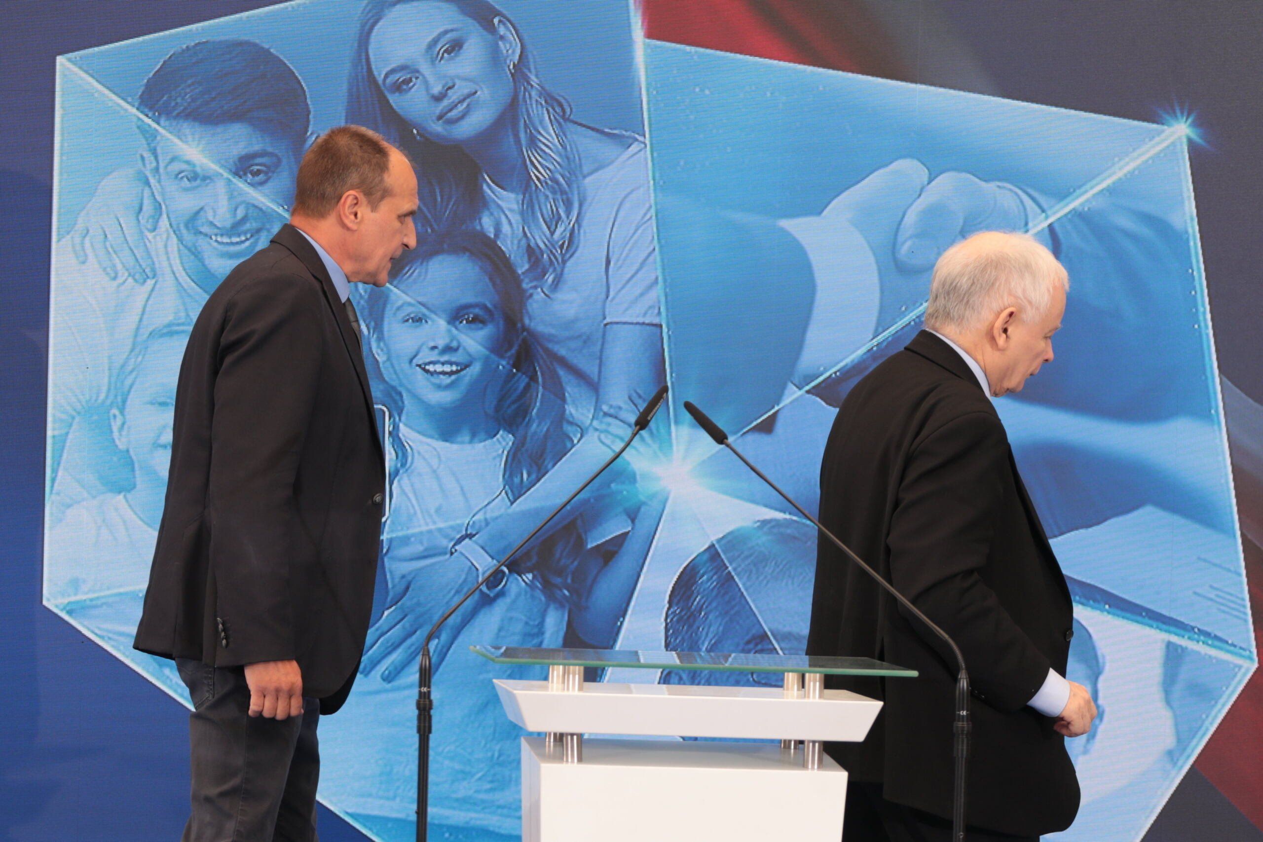 Niski męzczyzna (Kaczyński) i idący za nim wyższy (Kukiz)