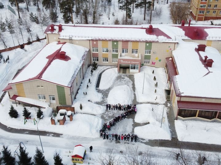 Widok z góry na podwórzu hospicjum dzieci ustawione w literę Z