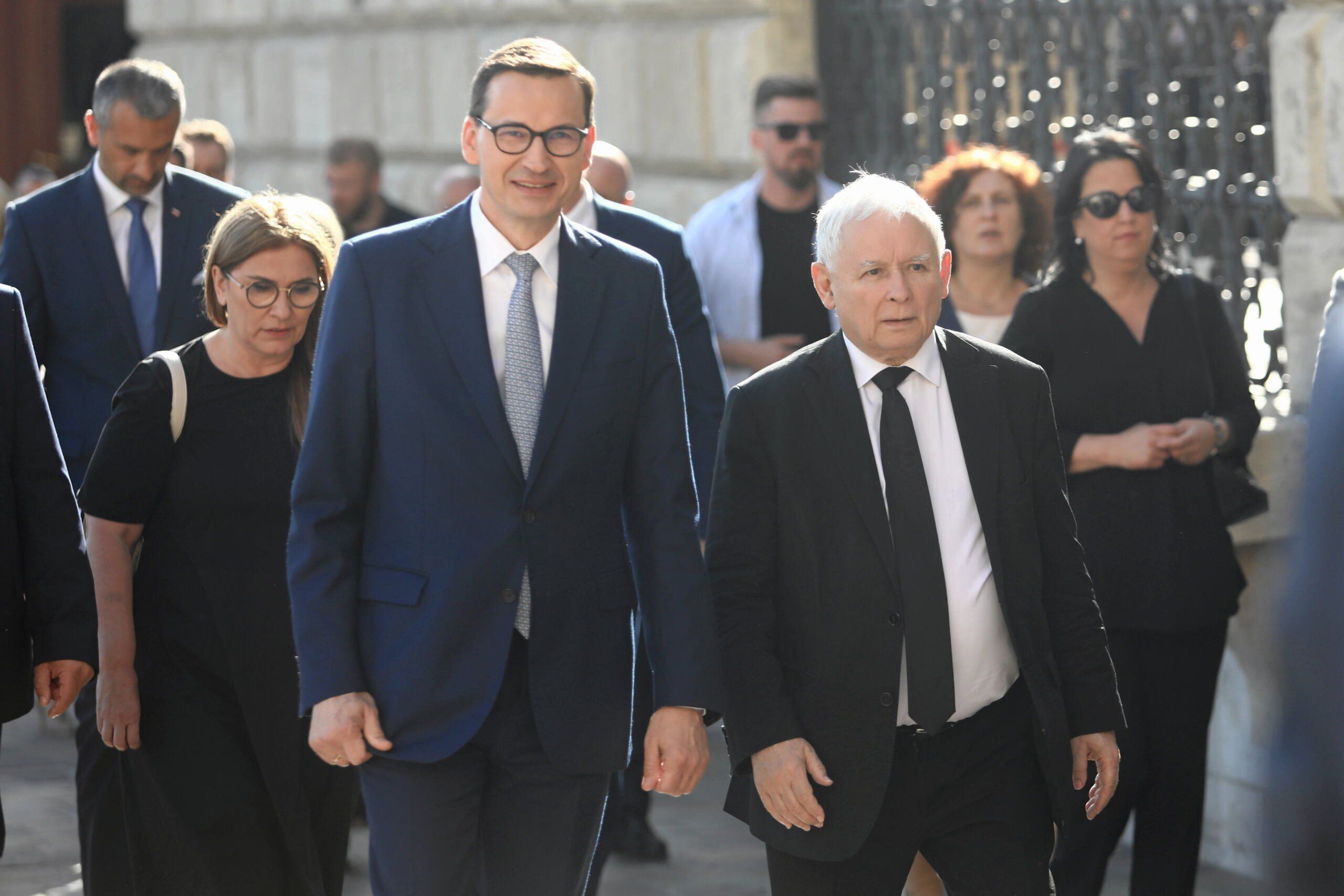 Dwaj mężczyźni w garnitiuach (wysoki i niski) idą: Mateusz Morawiecki i Jarosław Kaczyński