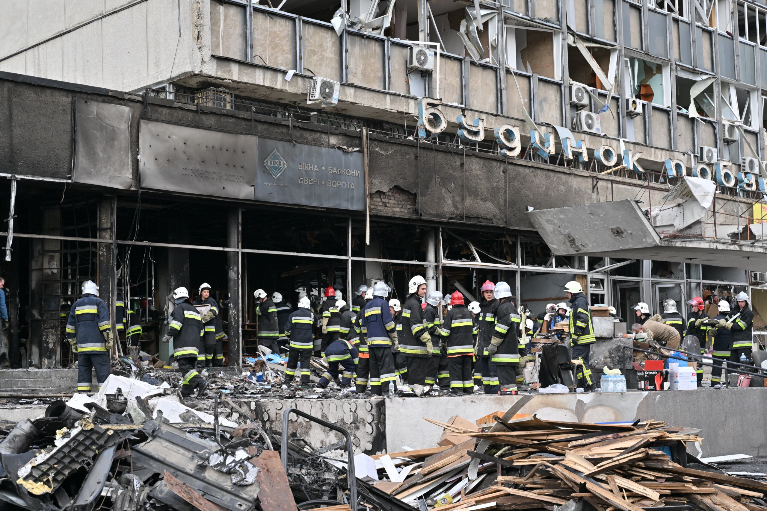 Firefighters remove rubbles out of a damaged building following a Russian airstrike in the city of Vinnytsia, west-central Ukraine on July 14, 2022. - At least 20 people were killed Thursday by Russian strikes on a city in central Ukraine, bombings described as "an openly terrorist act" by Ukrainian President Volodymyr Zelensky. (Photo by Sergei SUPINSKY / AFP)