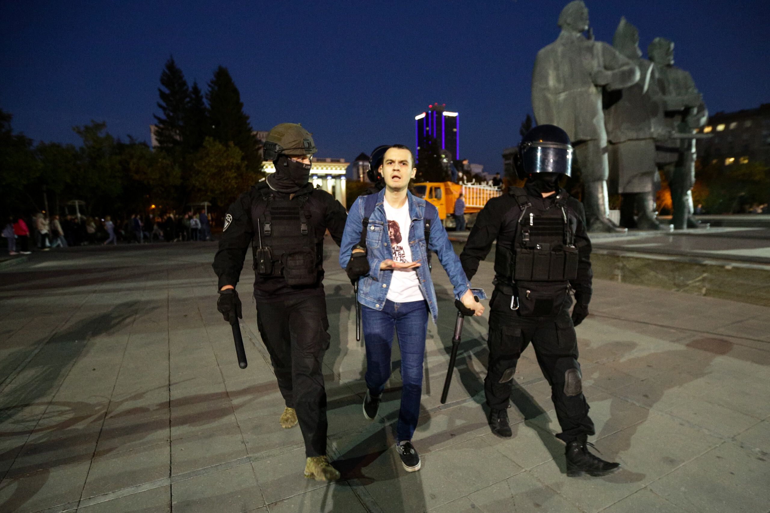 mężczyzna prowadzony przez dwóch policjantów