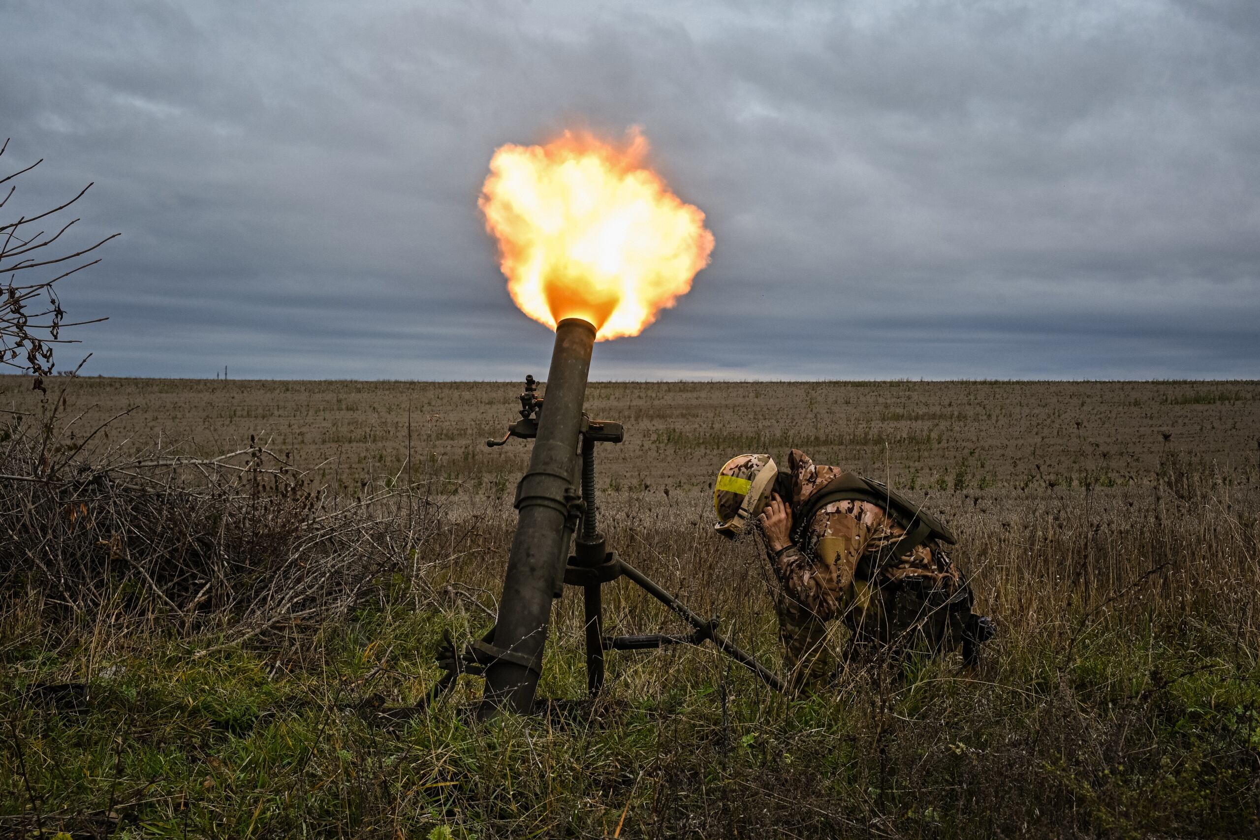 A member of Ukrainian National Guard fires a mortar launcher at a position along the front line in Kharkiv region on October 25, 2022, amid the Russian invasion of Ukraine. (Photo by SERGEY BOBOK / AFP)