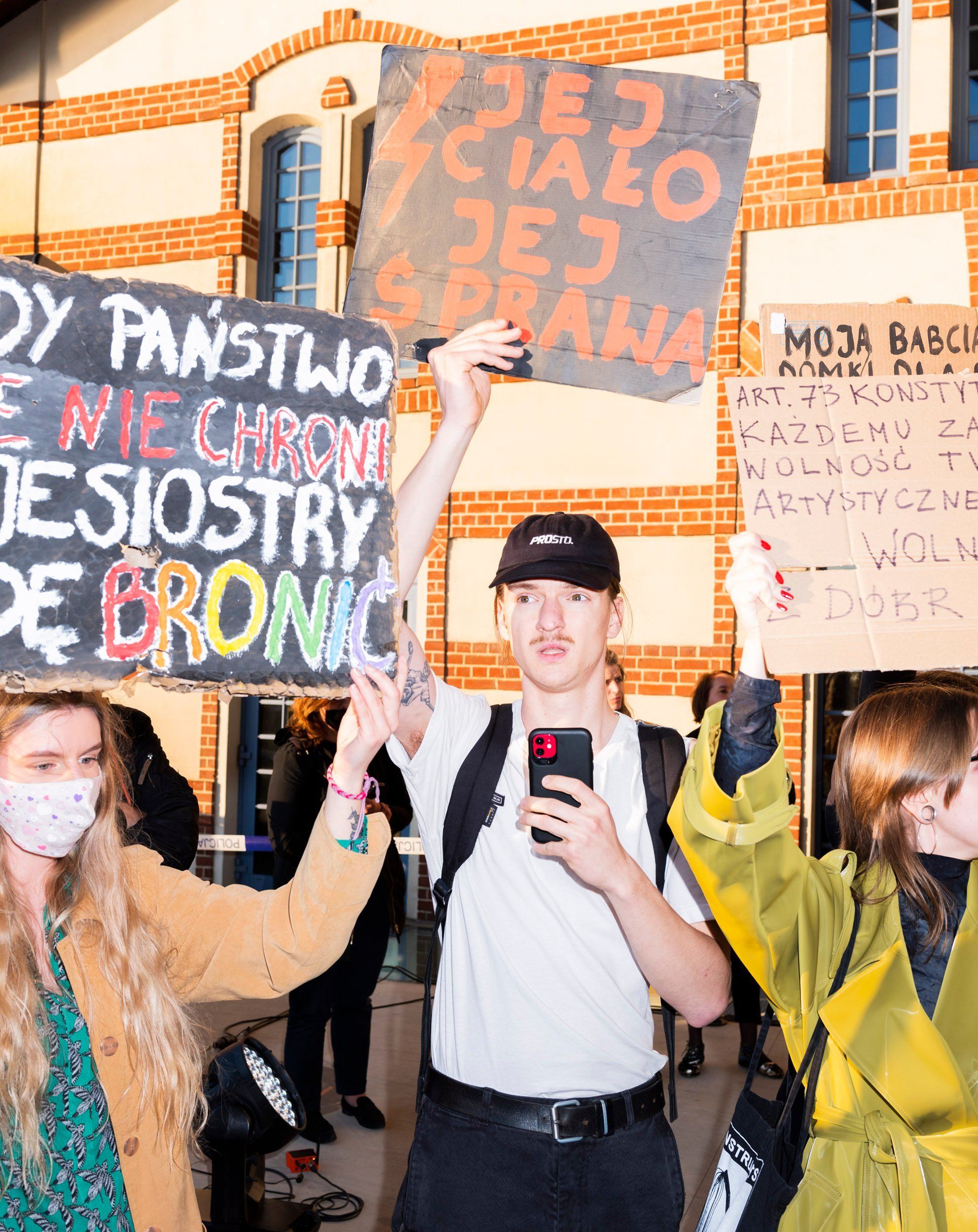 demonstranci trzymaja w rękach plakaty z hasłami w obronie kobiet
