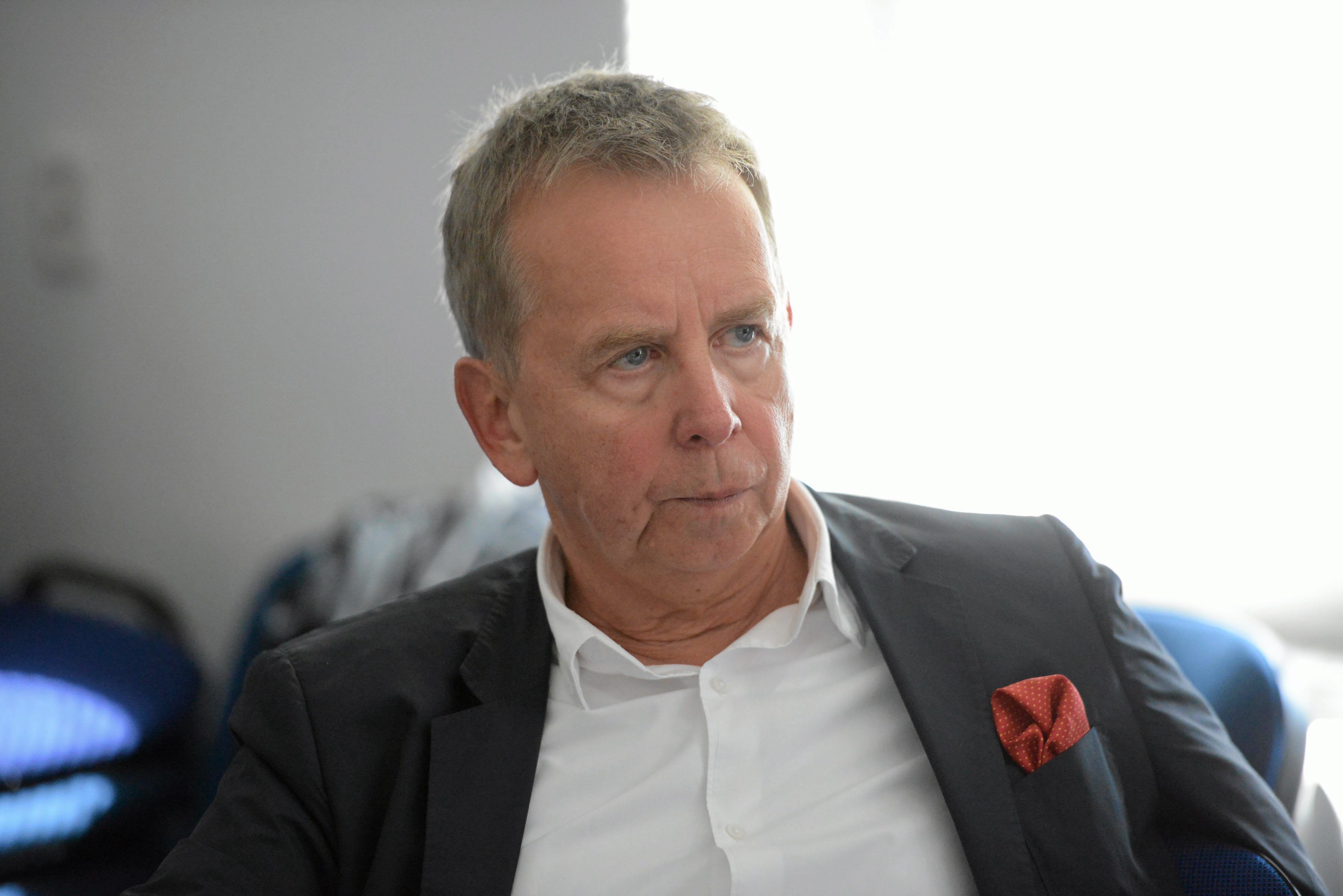 50-latek w marynarce i koszuli bez krawata