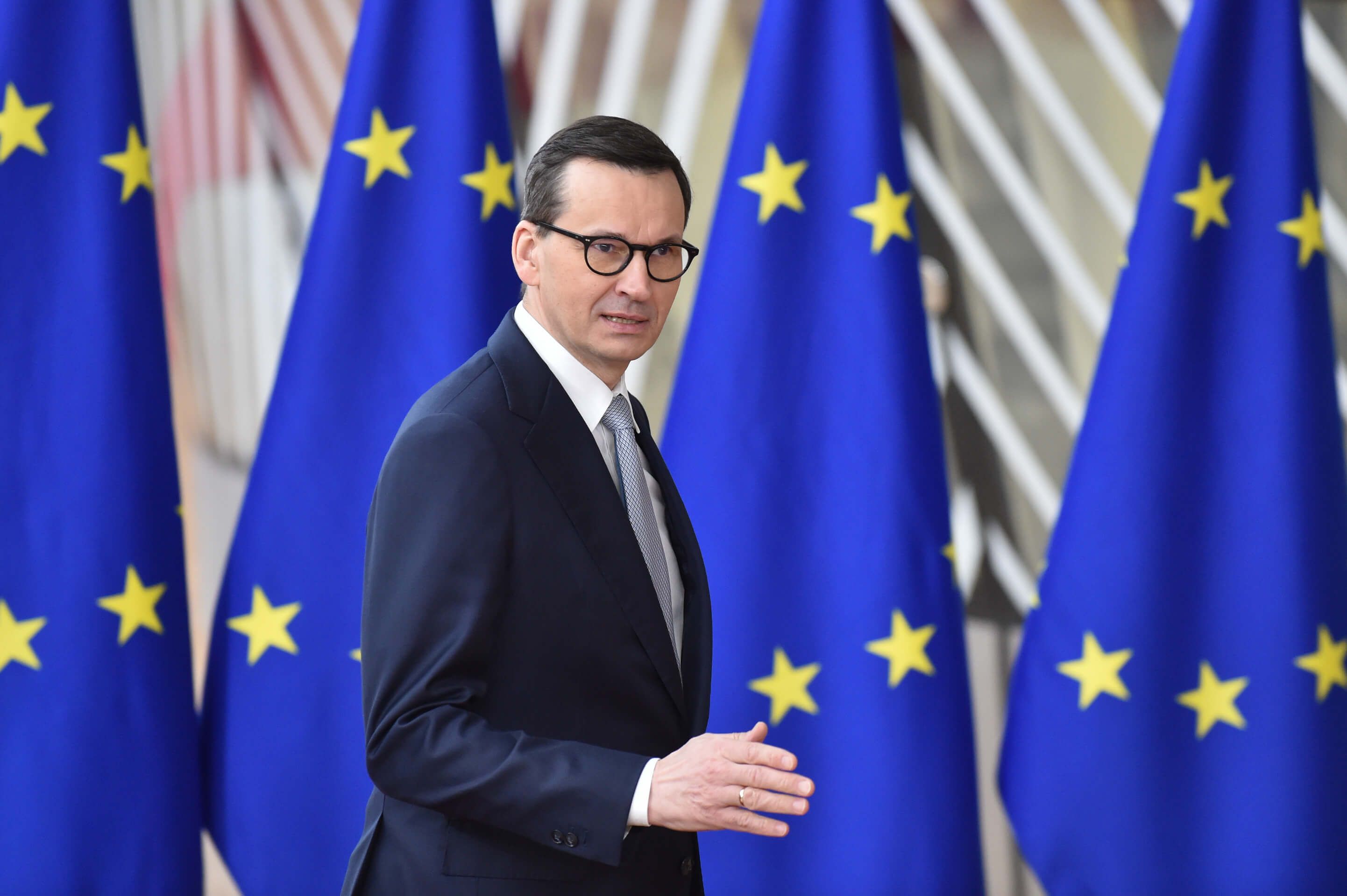 Premier Polski Mateusz Morawiecki na tle unijnych flag zmierza na posiedzenie Rady Europejskiej 24 marca 2023 roku w Brukseli. To m.in. podczas tego posiedzenia negocjowane było ogłoszone dziś porozumienie w sprawie ograniczeń importowych produktów rolnych z Ukrainy.