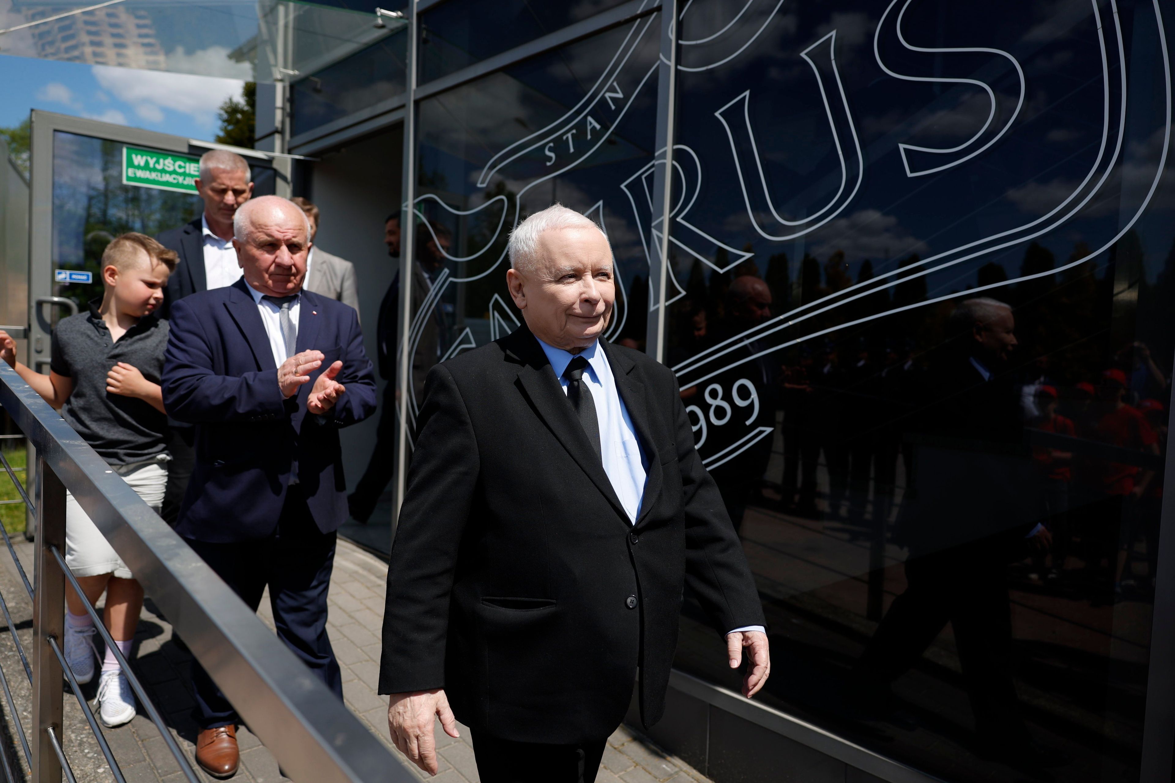 Zadowolony starszy mężczyzna w garniturze idzie schodami w dół