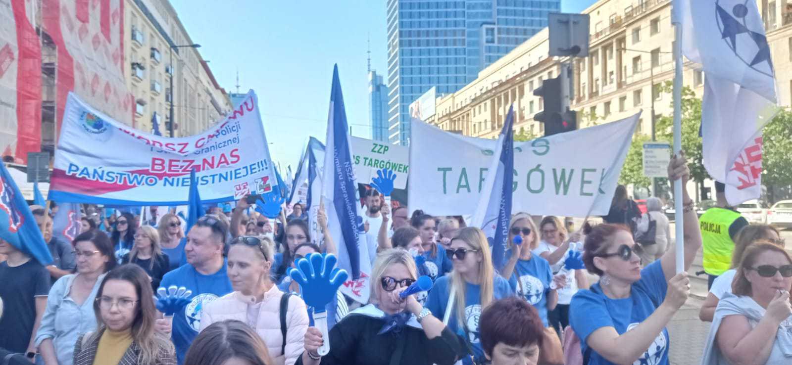 Ludzie z transparentami idący w marszu