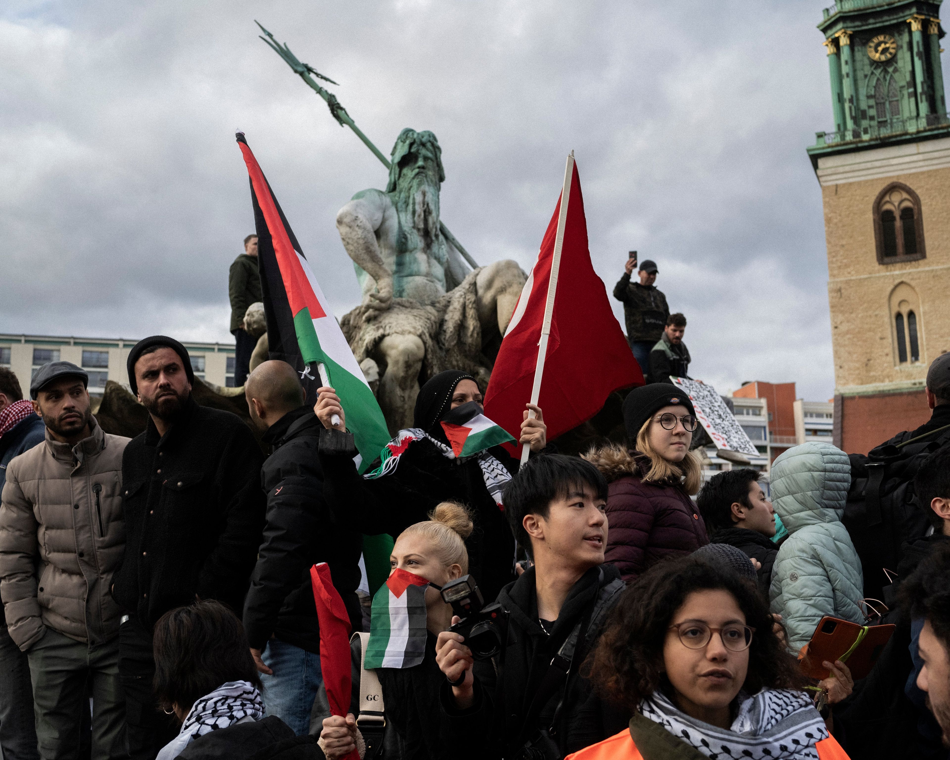 grupa protestujących przed pomnikiem