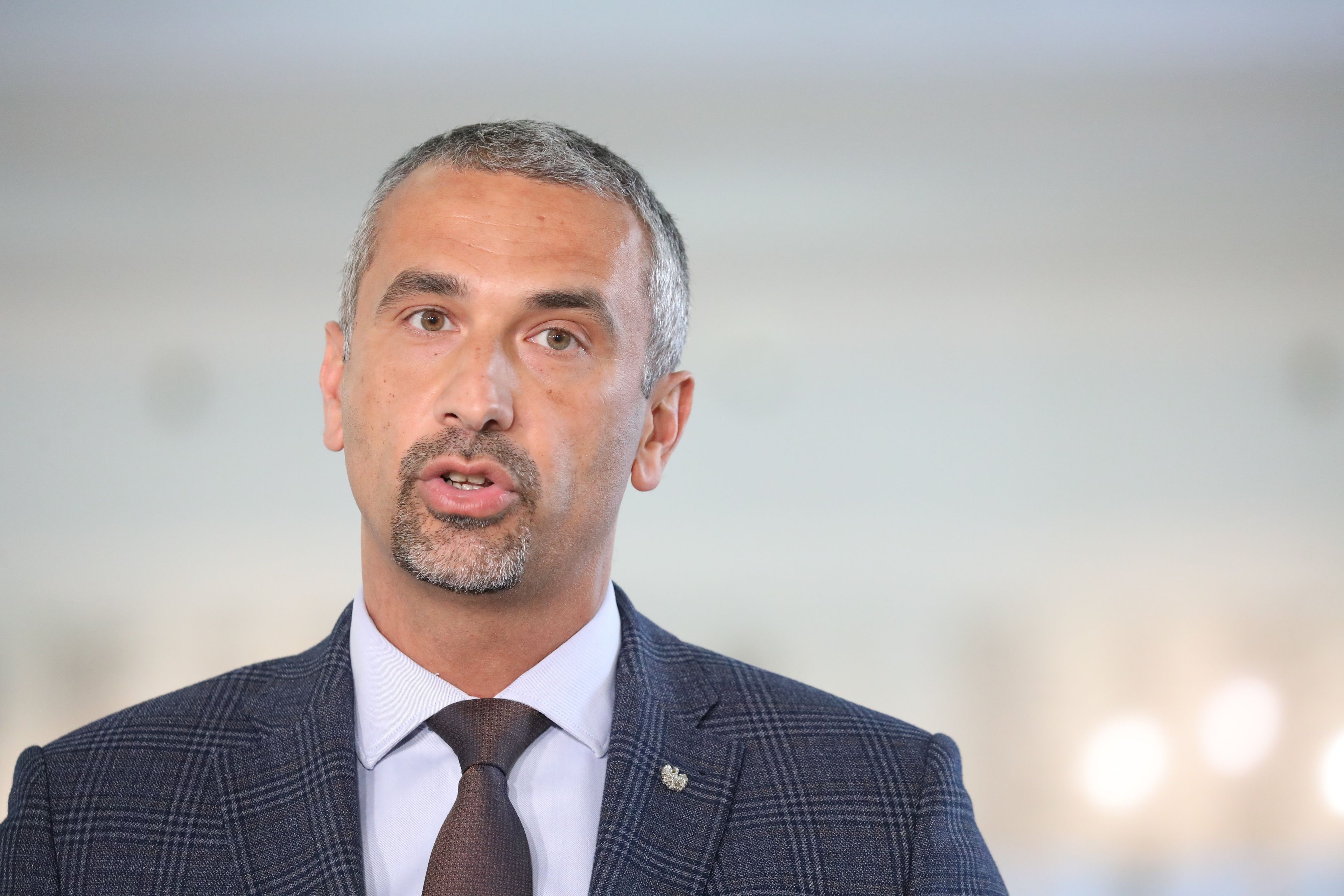 Na zdjęciu widzimy Marka Pęka - mężczyznę w średnim wieku, z krótko przystrzyżoną brodą, w garniturze.