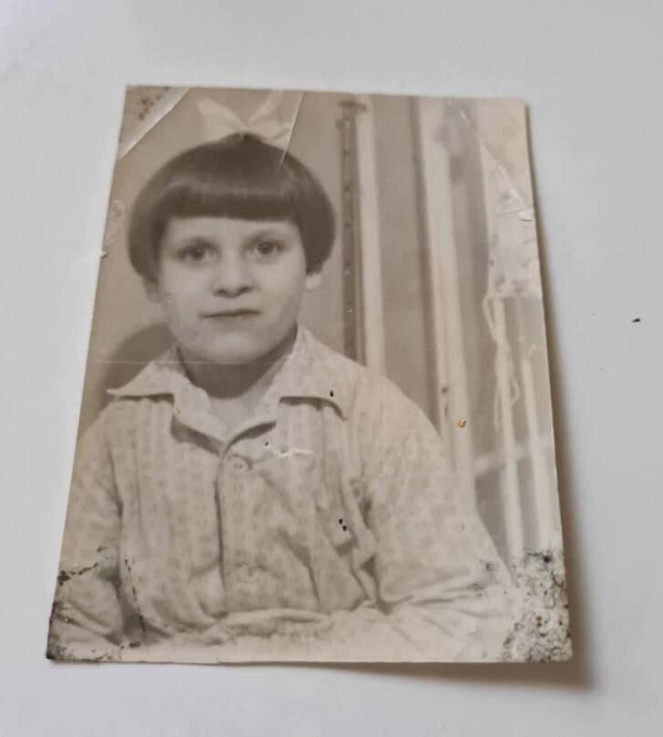 Dziewczynka w piżamie uśmiecha się do obiektywu. Emigracja
