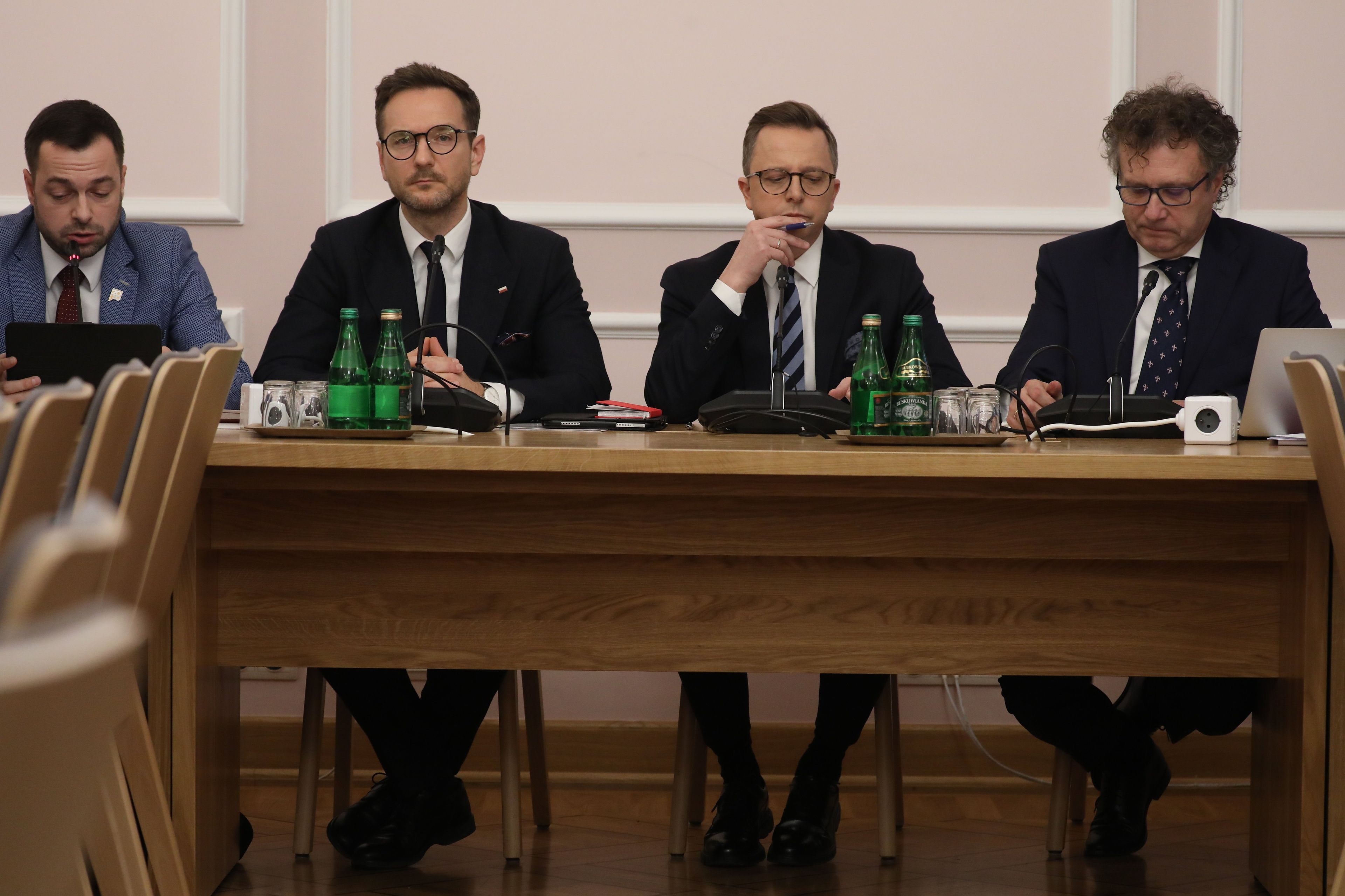 trzech posłów siedzi przy stole