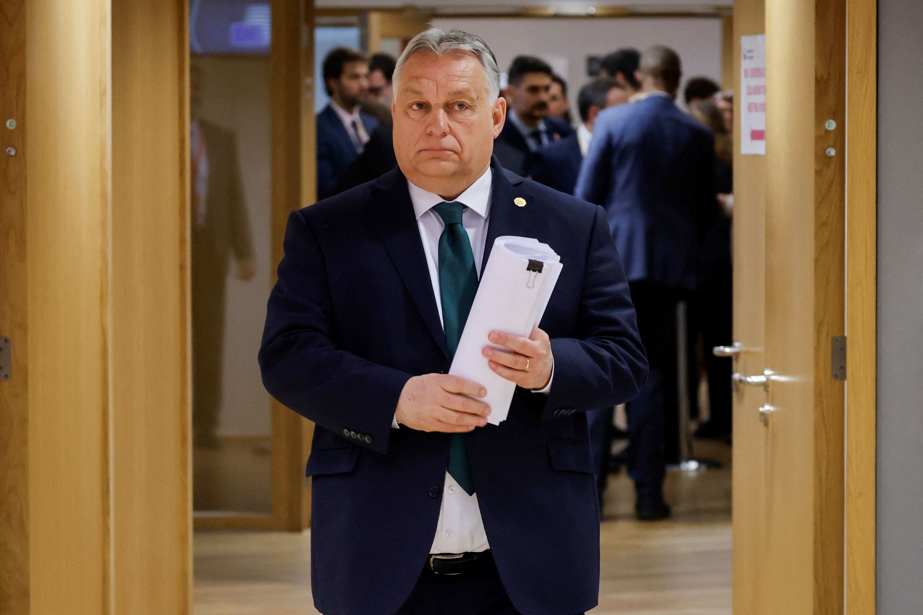 Otyły siwy mężczyzna z dokumentami w ręku, w garniturze