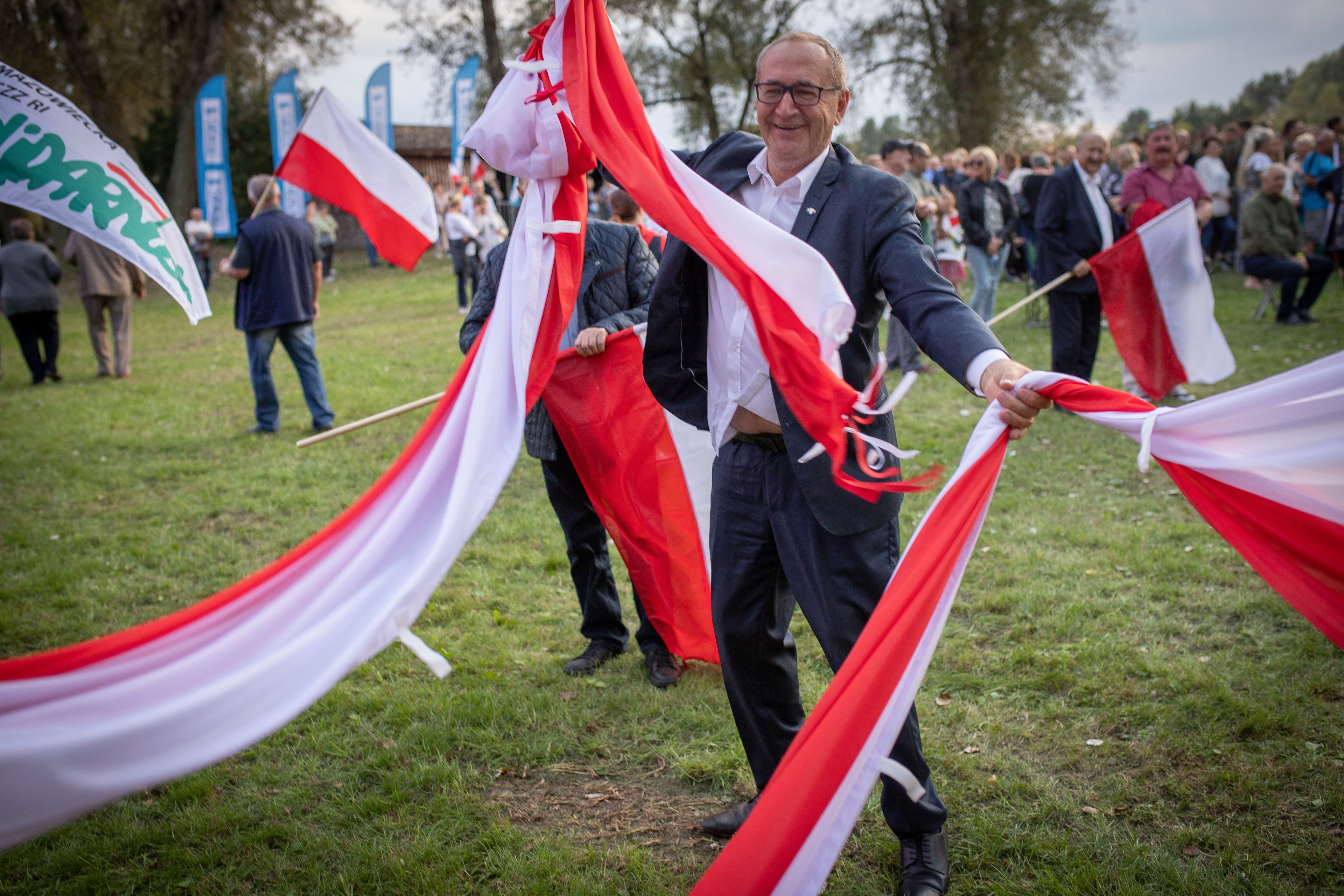 Poseł PiS powiewa białoczerwonymi szarfami