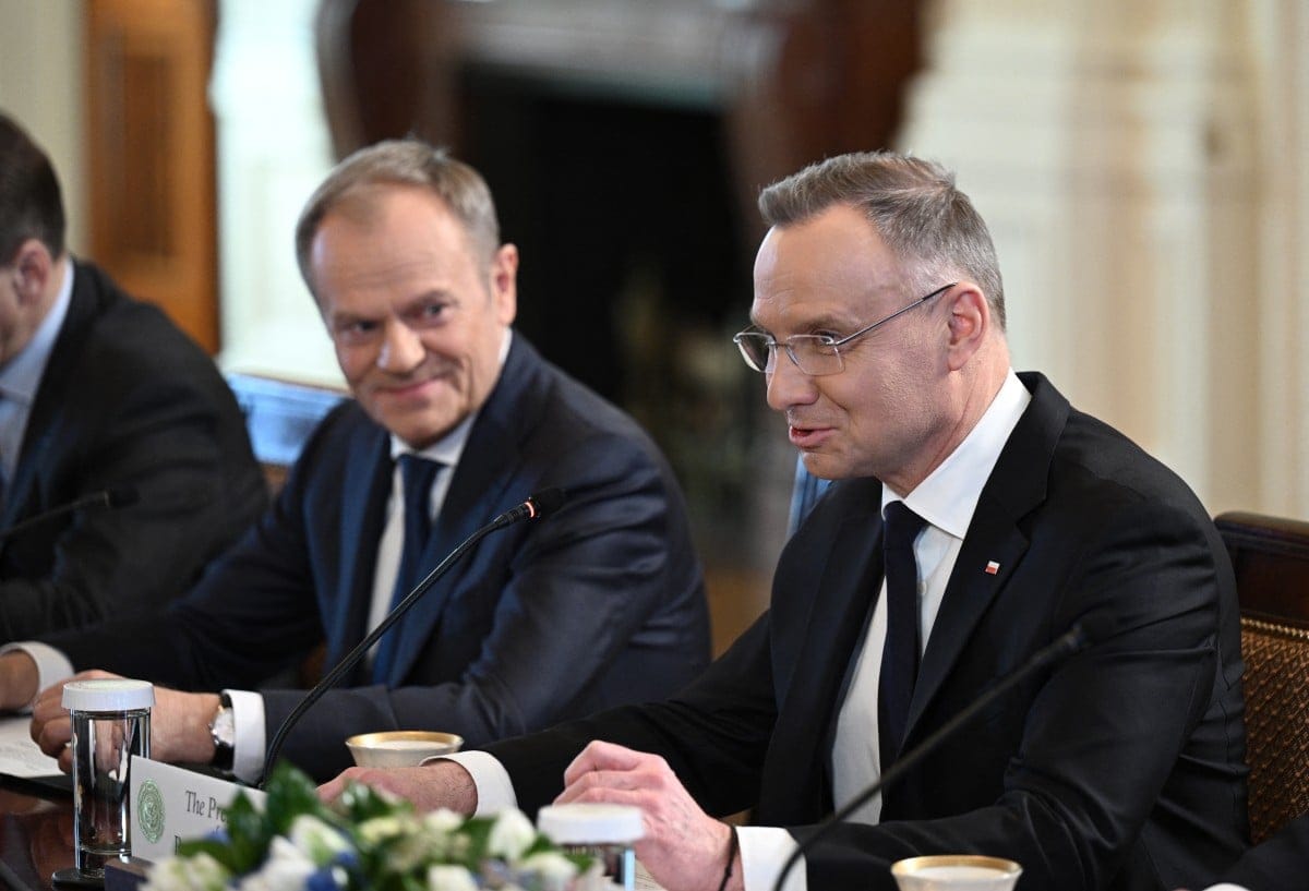 Dwóch mężczyzn przy stole obrad, jeden w Okularach